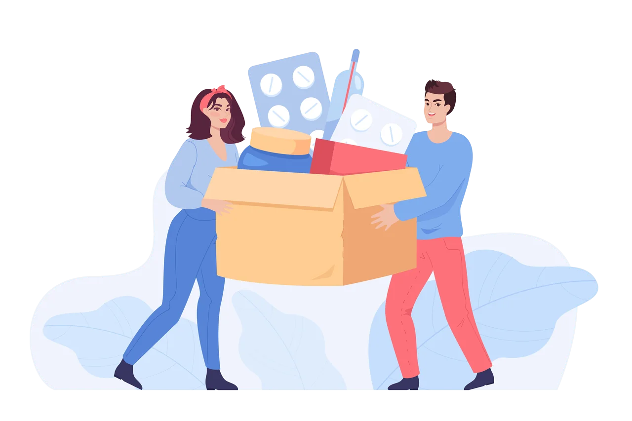 Two people carrying a cardboard box overflowing with supplies.