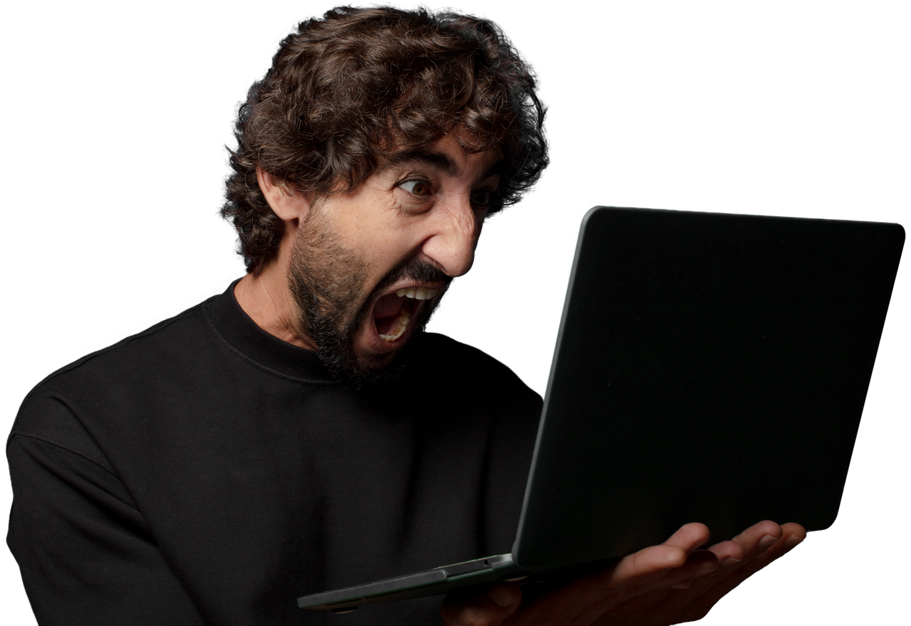 A man with curly hair shouting at the laptop in his hands